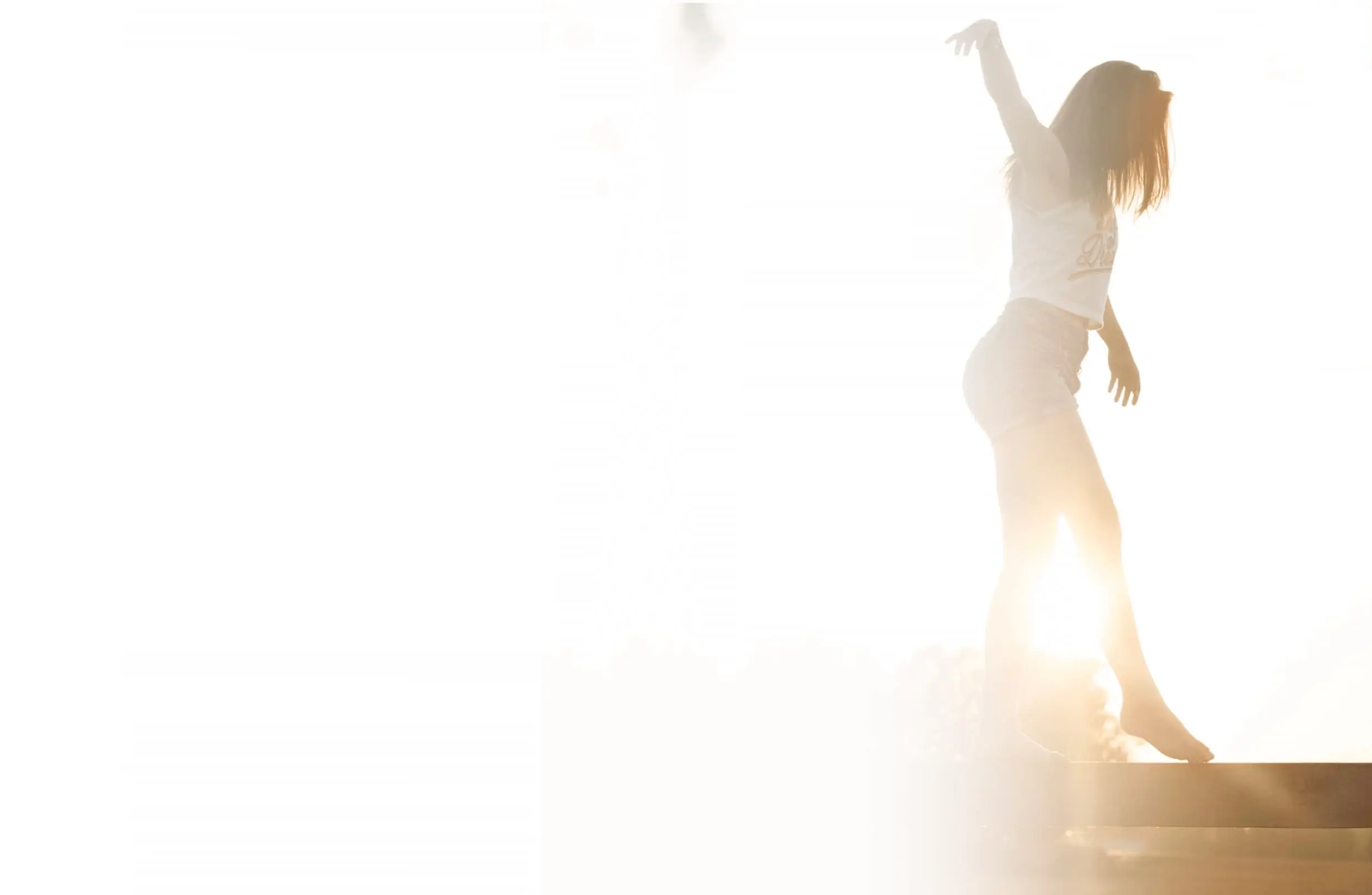 Femme marchant en équilibre sur un poteau en bois, dans un paysage lumineux, illustrant l’harmonie et le chemin vers soi en thérapie.